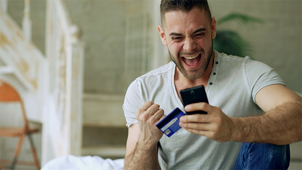 excited-man-using-smartphone-and-credit-card